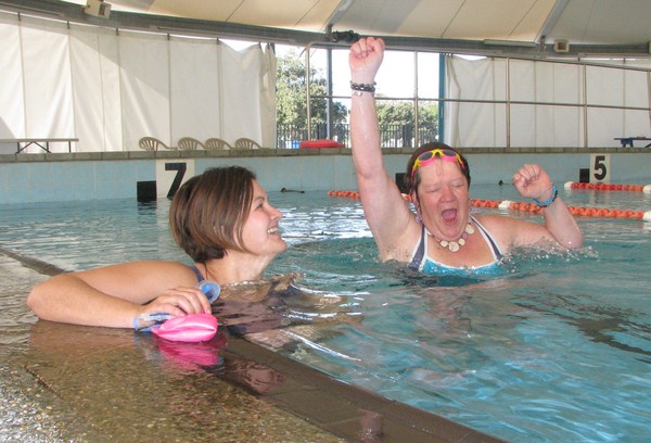 Sue 'The Turtle' Kahu–Kauika (pictured on the right) punches the air as she learns she is beating her Olympic Pool work colleagues in the Swim to Mahia challenge. Although it is the brain child of receptionist Shannon Friday (left) Sue is ahead of S